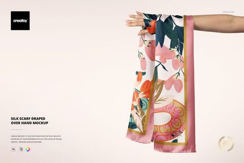 PSD mockup showing a patterned silk scarf with pink border, displayed over a hand on a plain light surface.