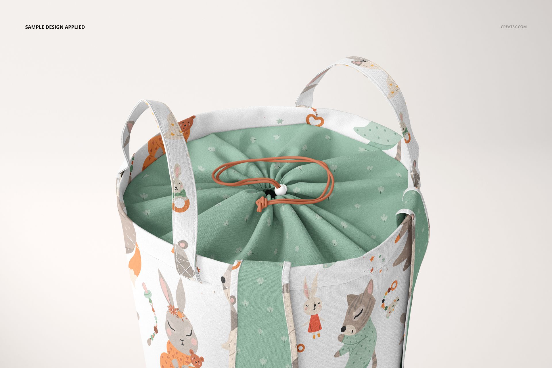 Kids storage basket mockup with animal illustrations and green drawstring top, shown from a close-up angle.