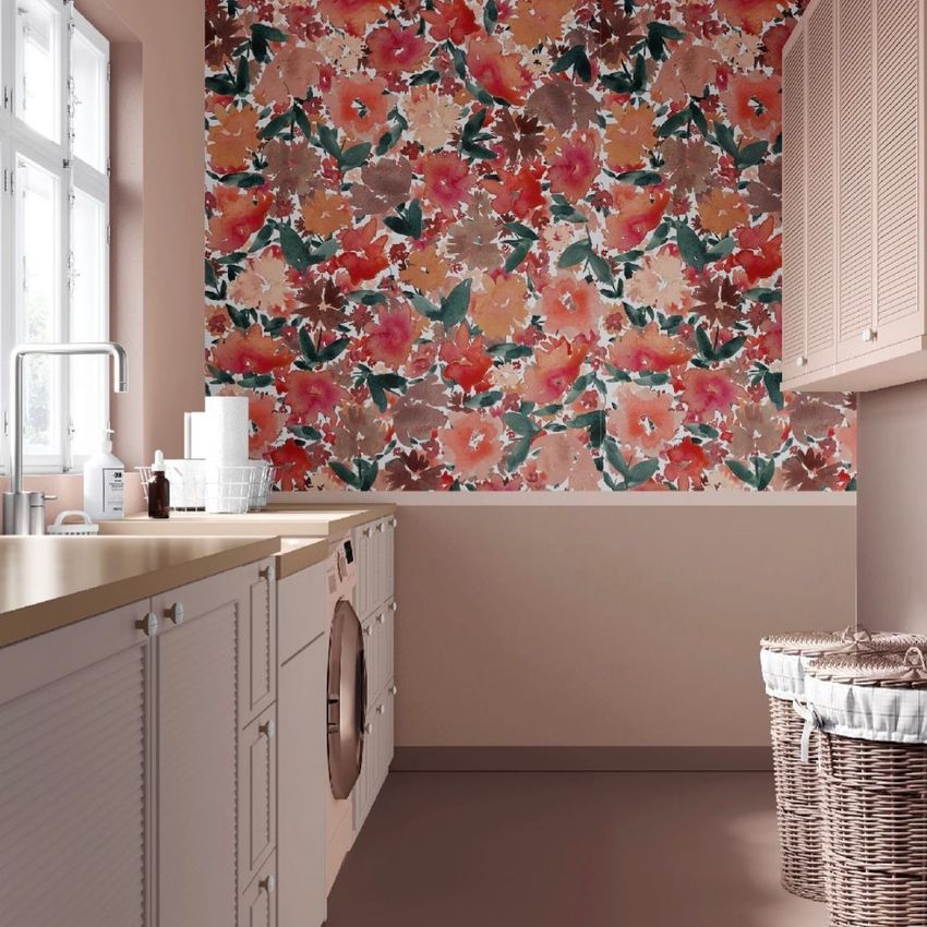 Laundry room mockup featuring a bold floral pattern wallpaper, beige cabinets, a washing machine, and wicker laundry baskets.