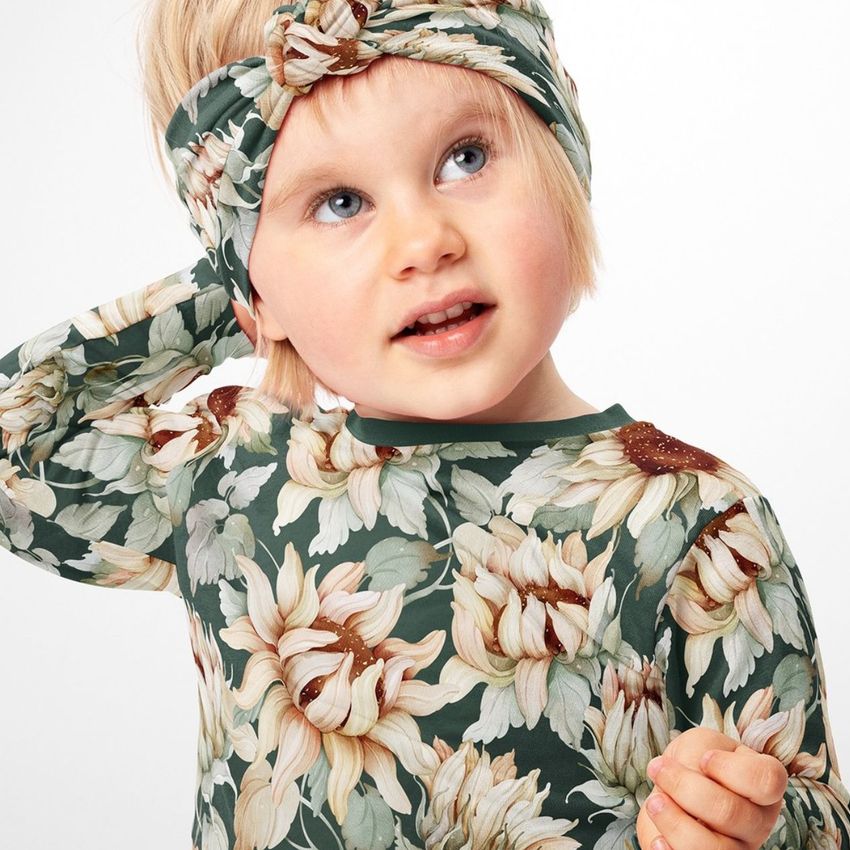 Child wearing a twist knot style headband mockup and matching long-sleeve shirt with a large sunflower pattern on a white background.