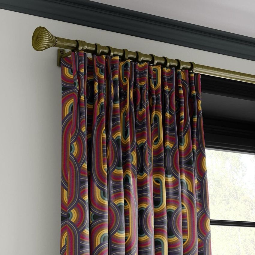 Drapery curtain mockup featuring a close-up of pleated fabric with a bold, multicolored geometric pattern on a brass rod.