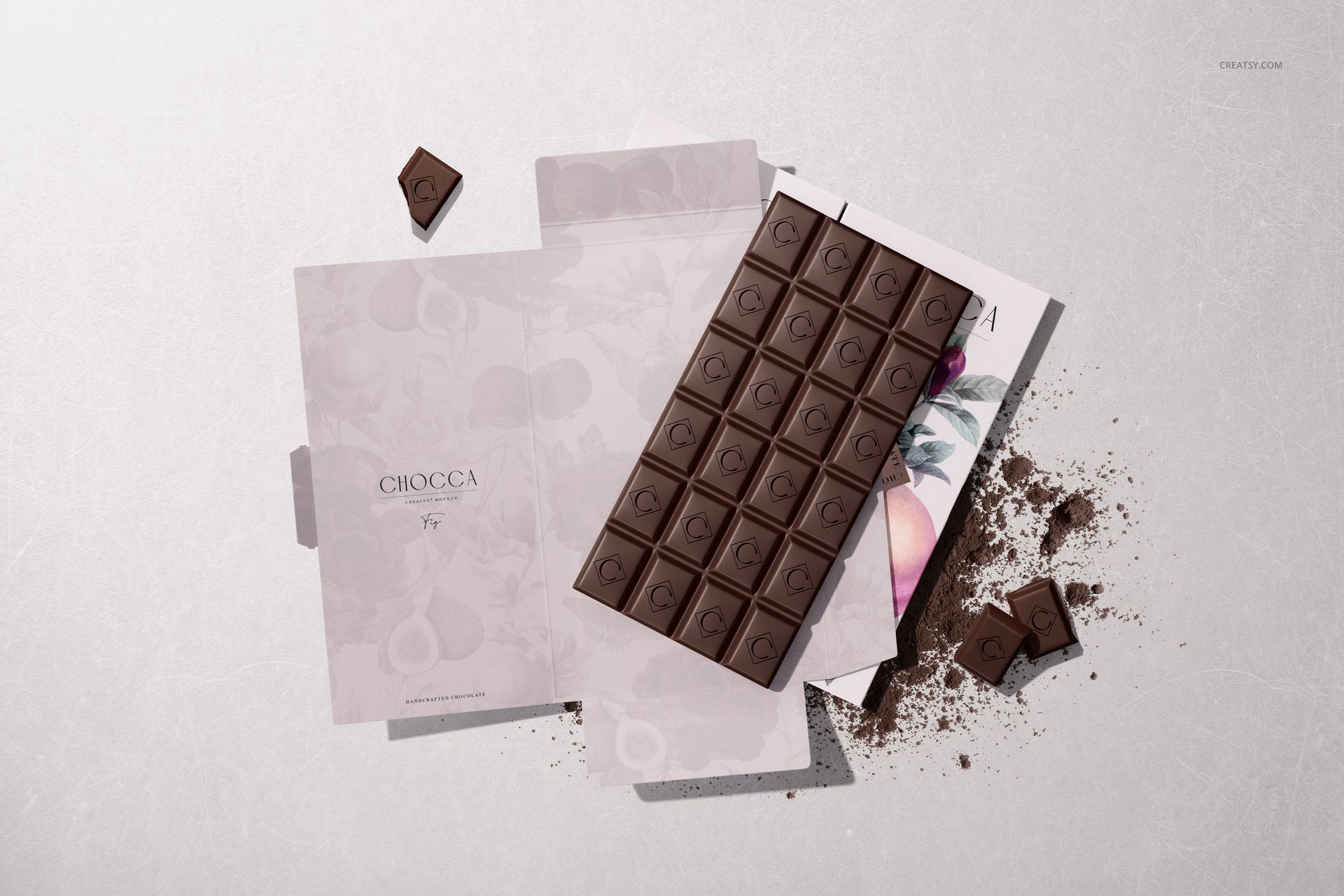 Chocolate bar packaging mockup showing an open box, chocolate pieces, and cocoa powder on a light surface from above.
