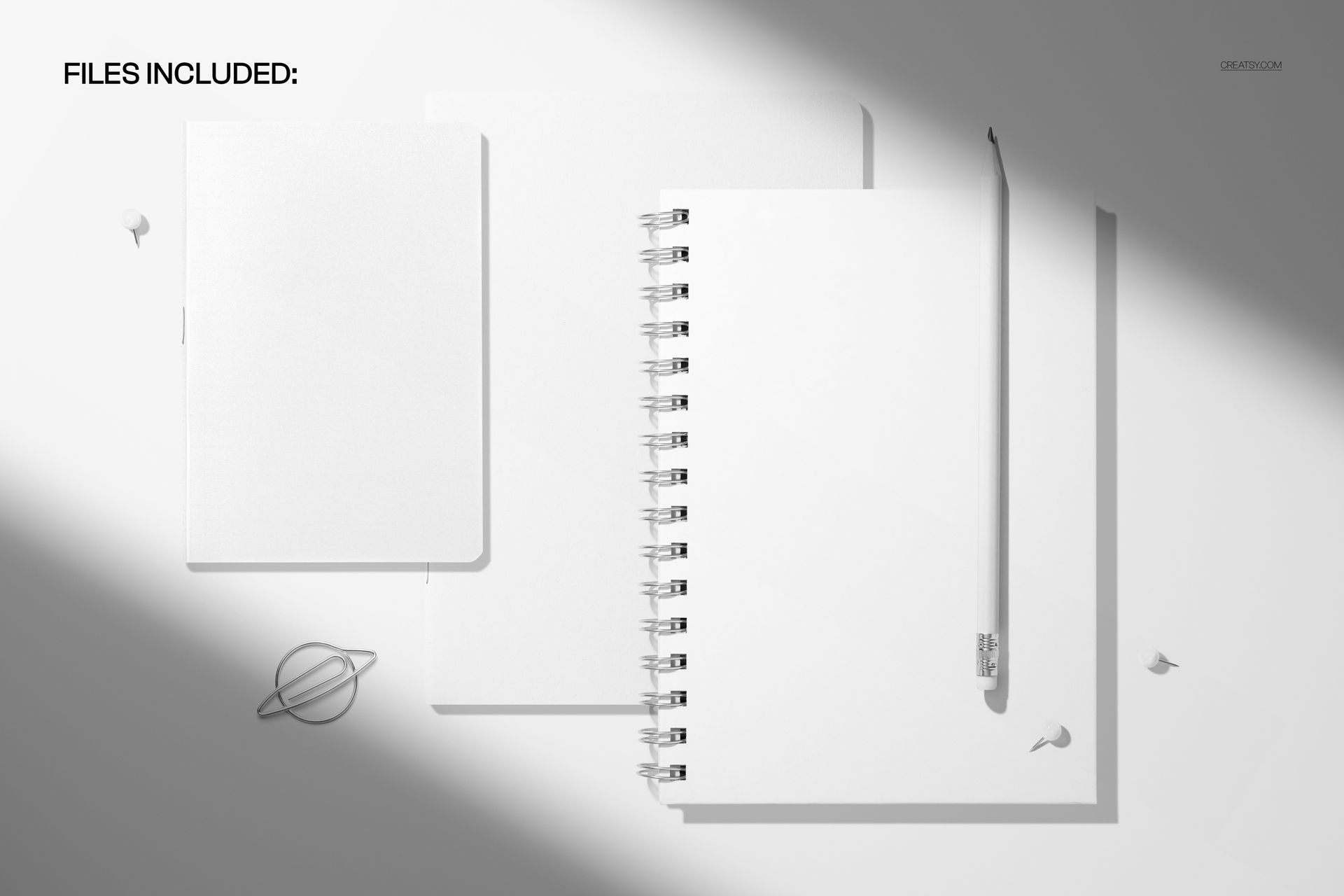 Top view of two softcover notebooks and a spiral journal mockup with blank white covers on a light surface.