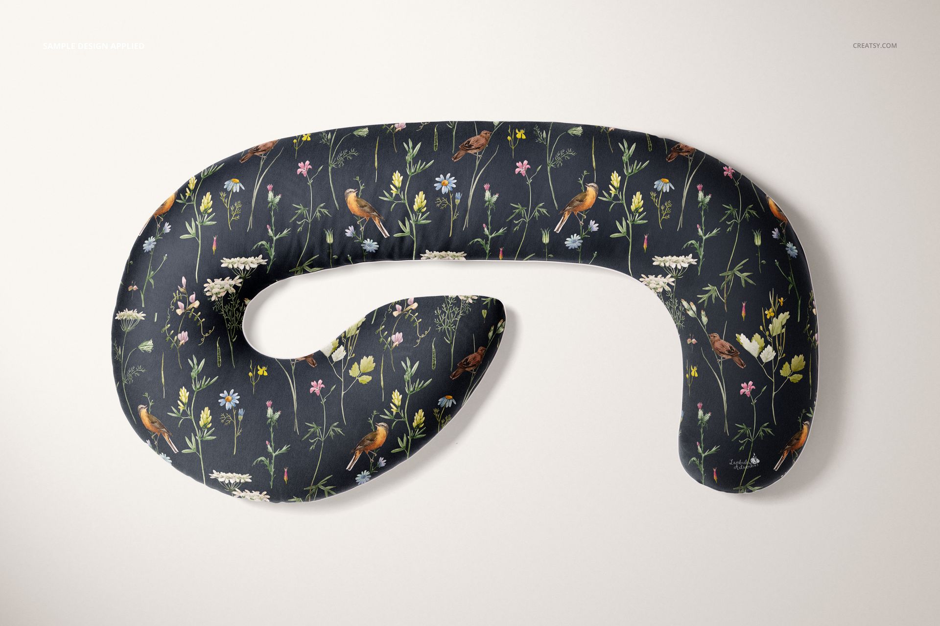 Pregnancy pillow mockup featuring a curved shape and floral design, displayed flat against a neutral backdrop.
