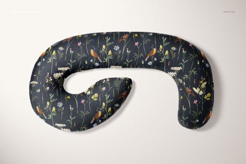 Pregnancy pillow mockup featuring a curved shape and floral design, displayed flat against a neutral backdrop.