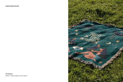 Fringed woven throw blanket mockup featuring a colorful abstract pattern and phrase, shown on a grassy lawn.
