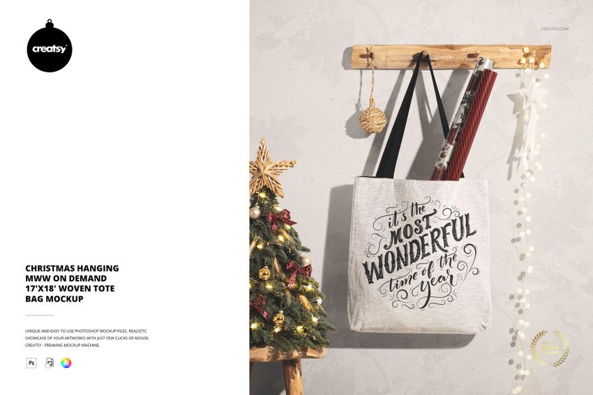 Christmas woven tote bag mockup displayed on a wall hook, with ornaments and a festive tree in the background.