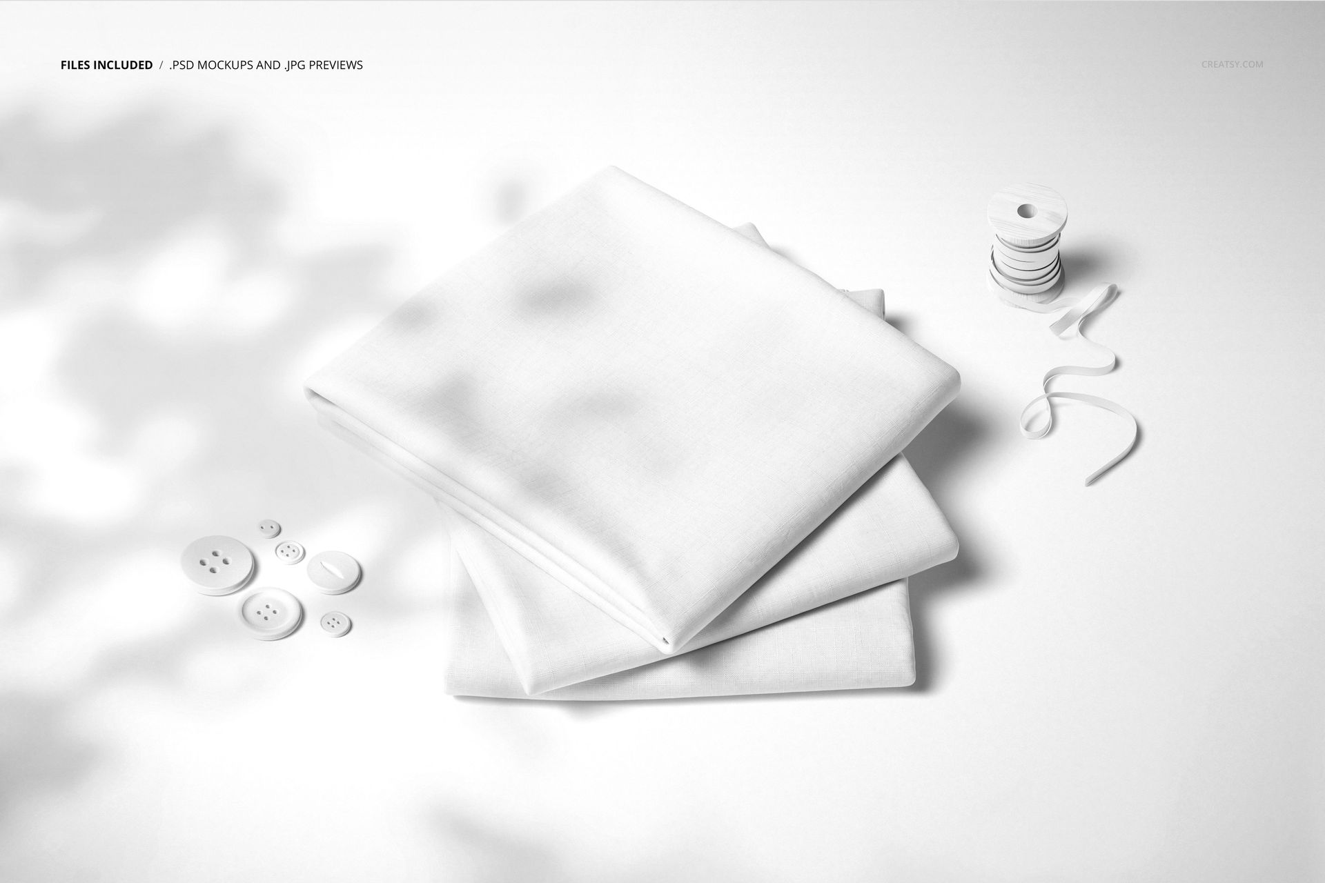 Folded fabrics mockup featuring stacked white textile pieces, buttons, and ribbon on a clean, minimalist background.