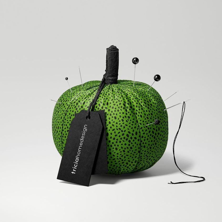 Fabric pumpkin mockup featuring a green pumpkin with black polka dots, black pins, and a black tag on a light gray background.