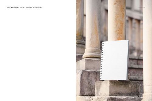 Front view of a spiral-bound notebook mockup placed on old stone stairs, with textured pillars in the background.