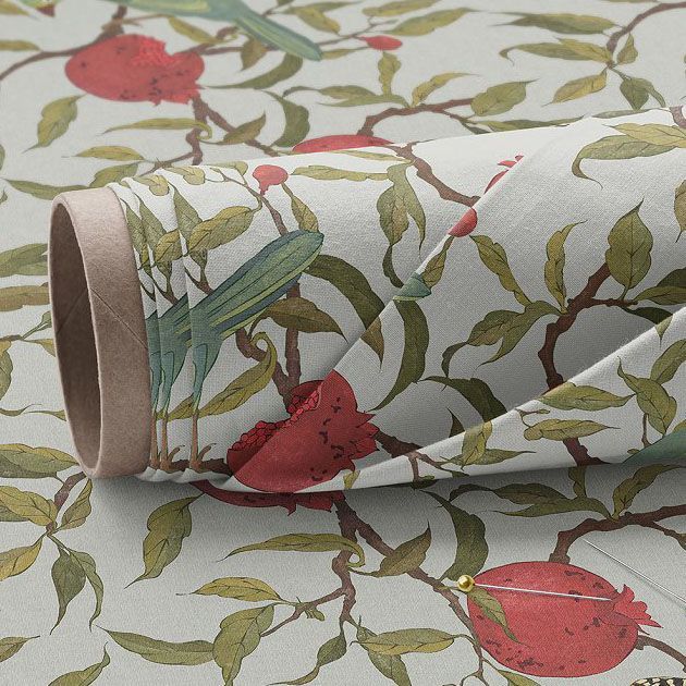 Fabric roll mockup featuring a close-up of patterned fabric with green leaves and red pomegranates on a light background.