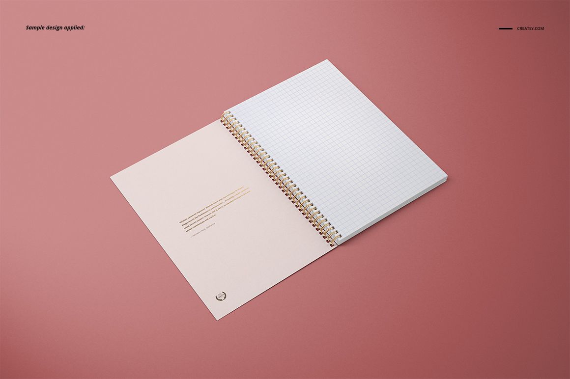 Open A4 notebook mockup with gold spiral binding and grid paper, displayed on a solid pink background, top angle.