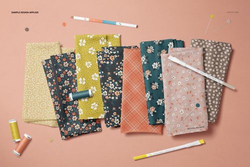 Floral and geometric jersey fabric mockup in a top view layout with sewing accessories on a peach background.