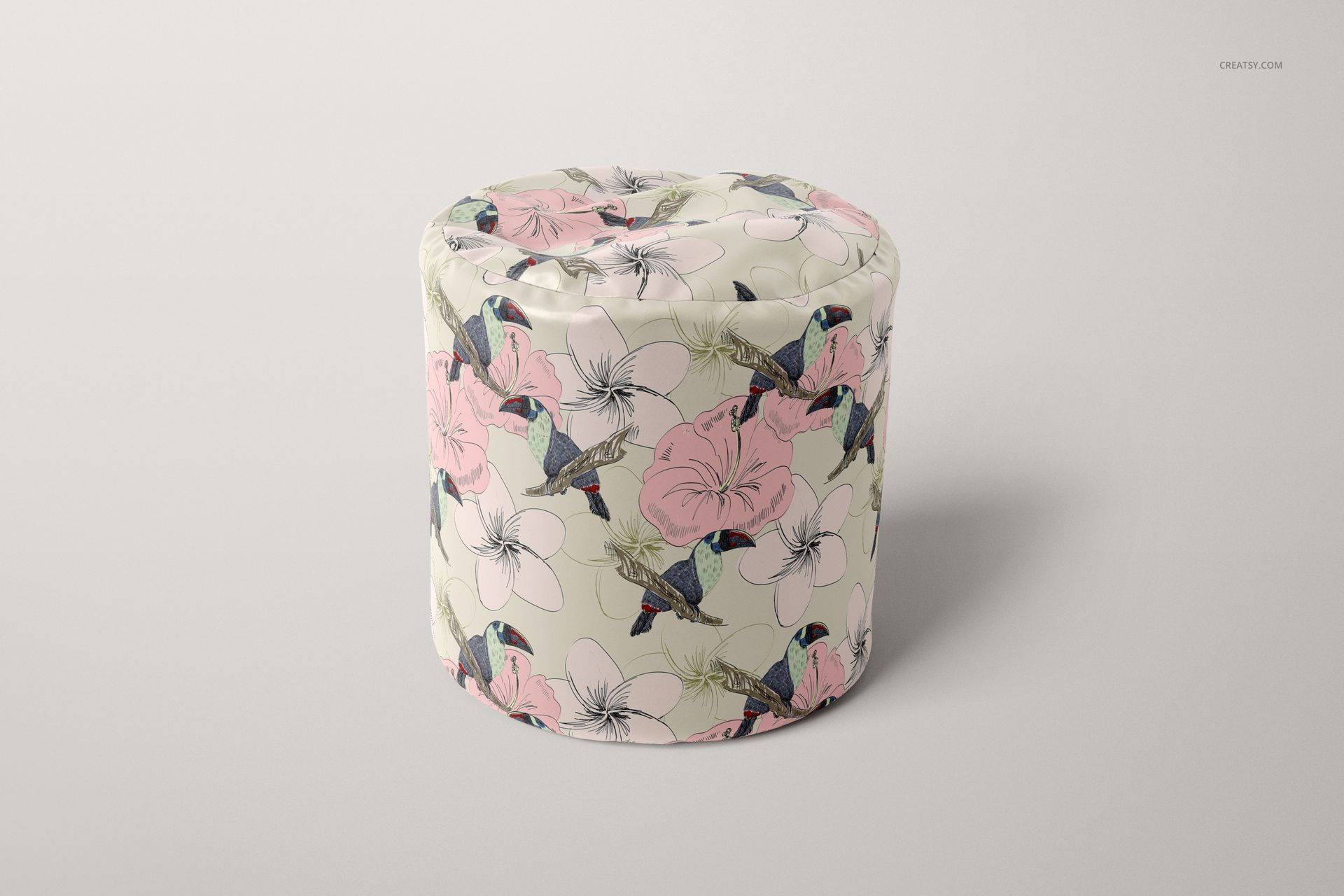 Cylinder-shaped bean bag featuring pink flowers and blue hummingbirds, displayed in a PSD mockup on a neutral surface.