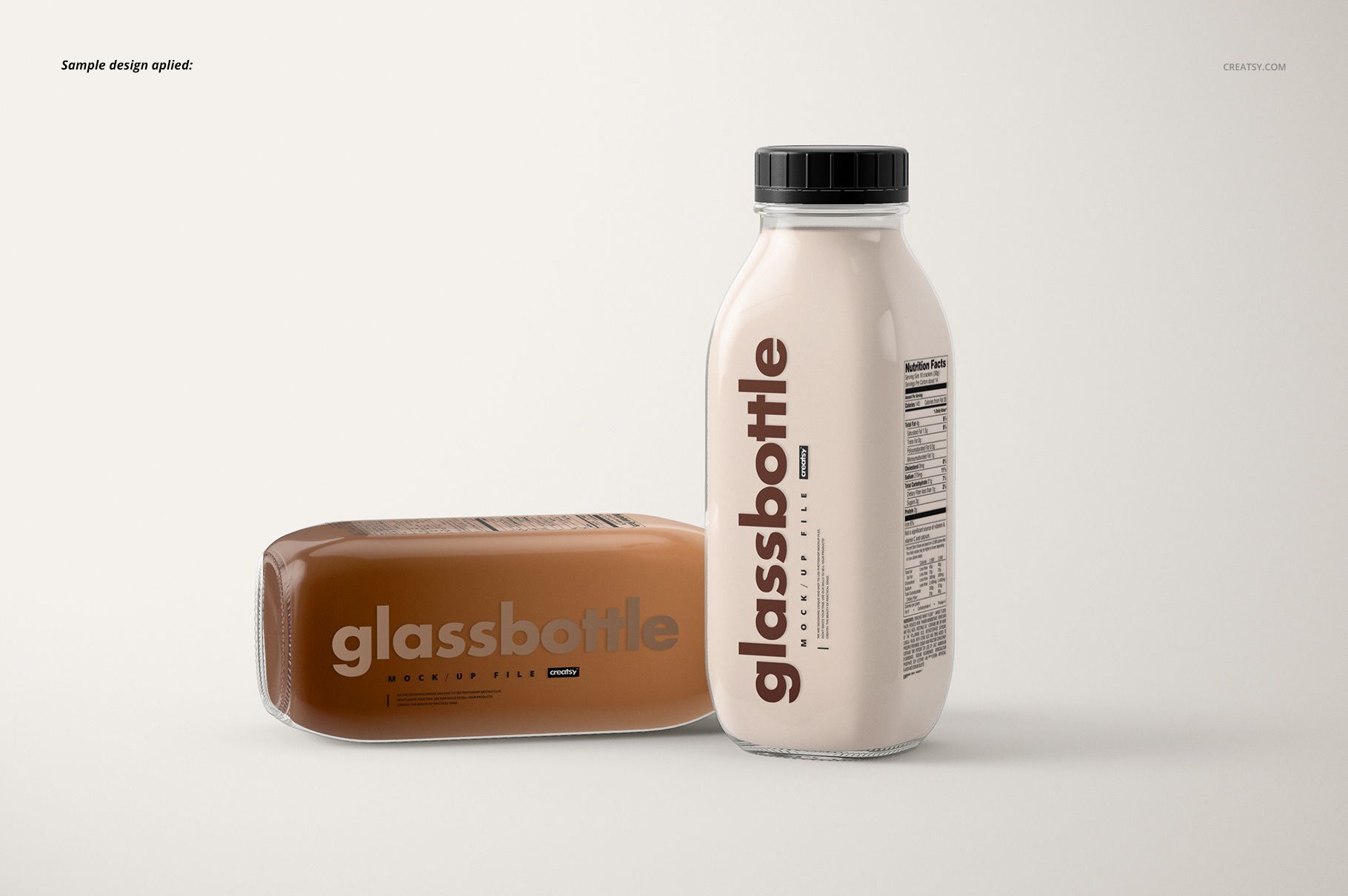 Glass bottle mockup set with two bottles, one vertical and one horizontal, both with clear labels and black lids.
