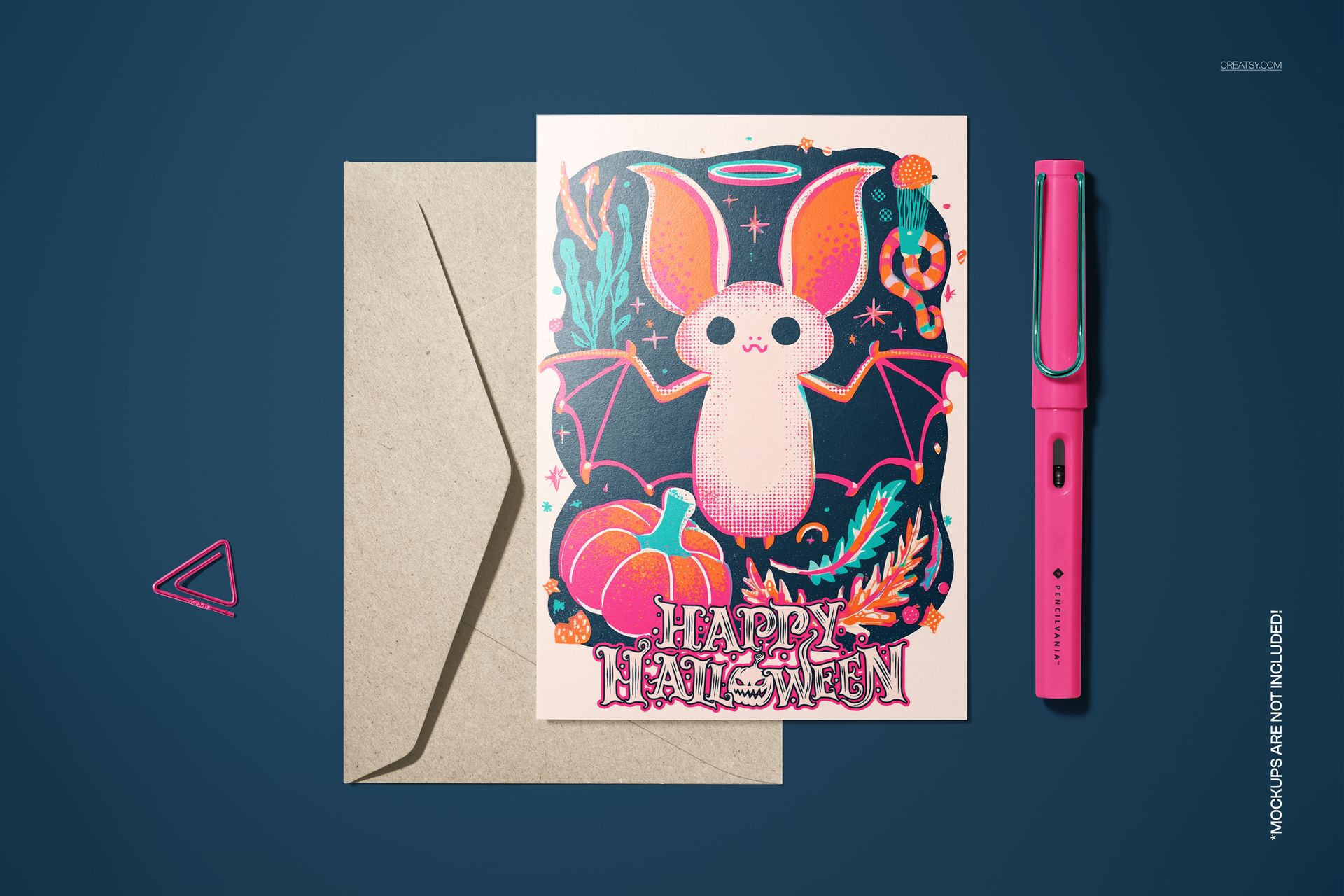 Halloween 5x7 card mockup showing a white bat graphic surrounded by pumpkins and foliage, with envelope and pen props.