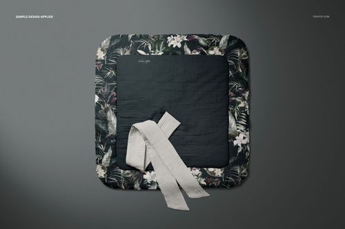 Top view of a muslin baby wrap mockup featuring a floral border and plain center, with a fabric tie placed on it.