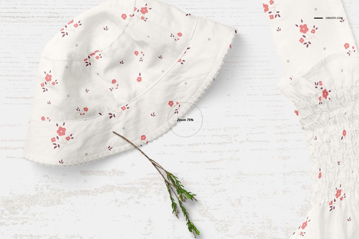 Baby summer set mockup featuring a white bucket hat and matching garment with pink floral pattern, top view.