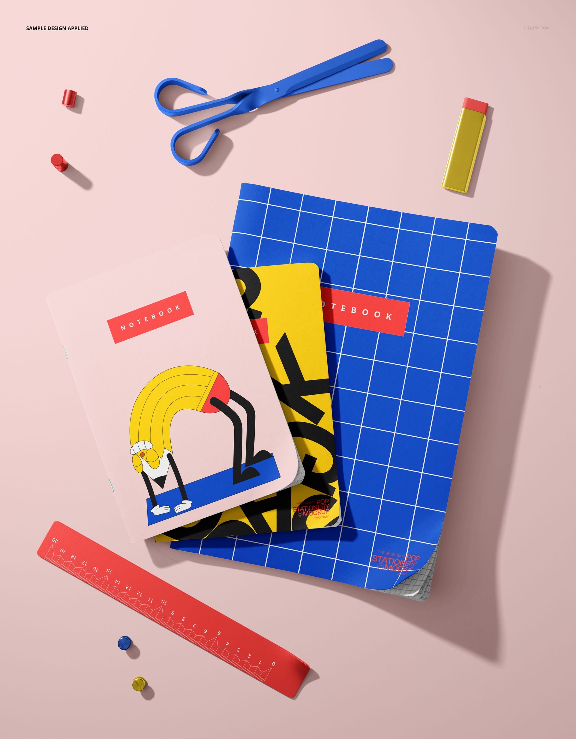 Stationery scene showing three notebooks mockup with vibrant covers, ruler, eraser, and scissors on a pastel surface.