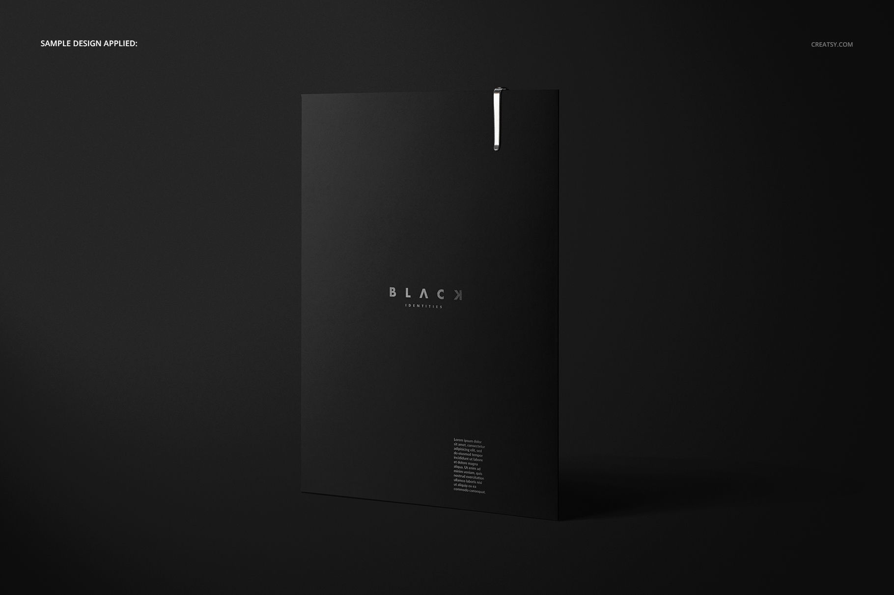 Front view of a black folder mockup standing upright on a dark surface, featuring minimal white text and a metallic accent.