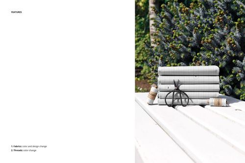 PSD mockup showing layered fabrics on a wooden bench outdoors, set against lush green conifers and natural sunlight.