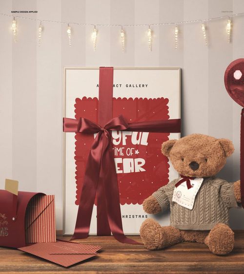 Front view of a Christmas-themed picture frame mockup with a red ribbon, teddy bear, and festive props on a wooden surface.
