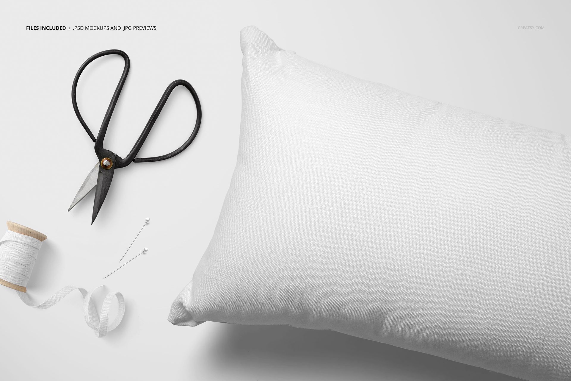 Rectangular white pillow mockup shown from above, with sewing tools including scissors, spool, and ribbon on the side.