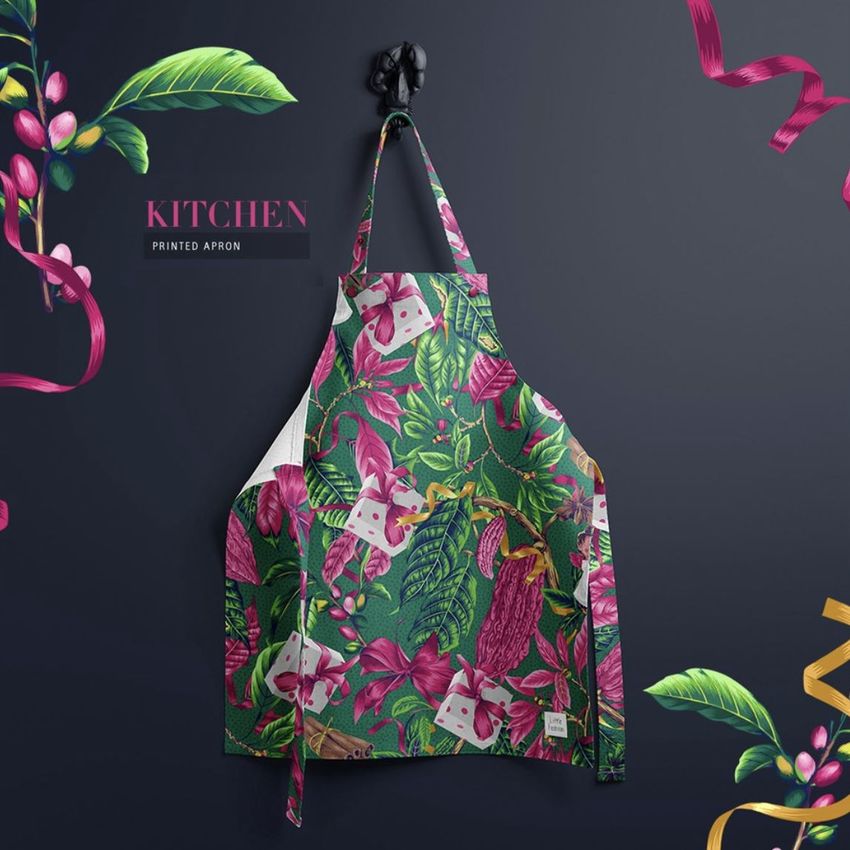 Kids apron mockup featuring a festive Christmas print with leaves, ribbons, and holiday motifs on a dark background.