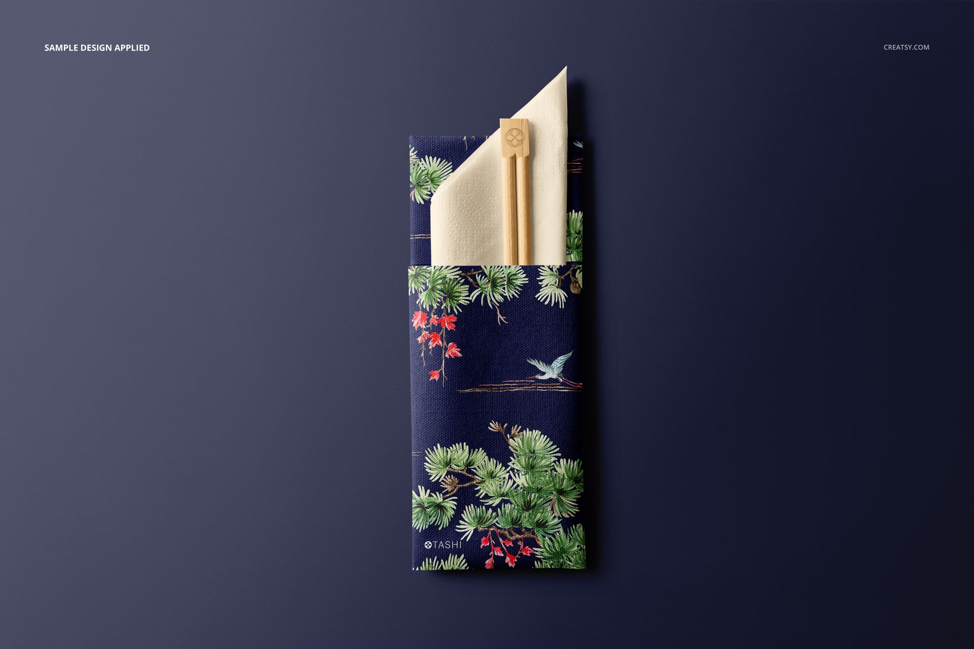 Mockup showing chopsticks and napkin in a sleeve featuring a nature-inspired pattern, set against a solid dark backdrop.