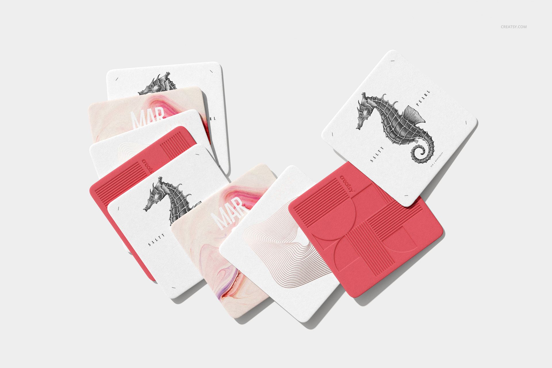 PSD mockup of square coasters with textured surfaces, including marine-themed and abstract designs in a minimalist setting.