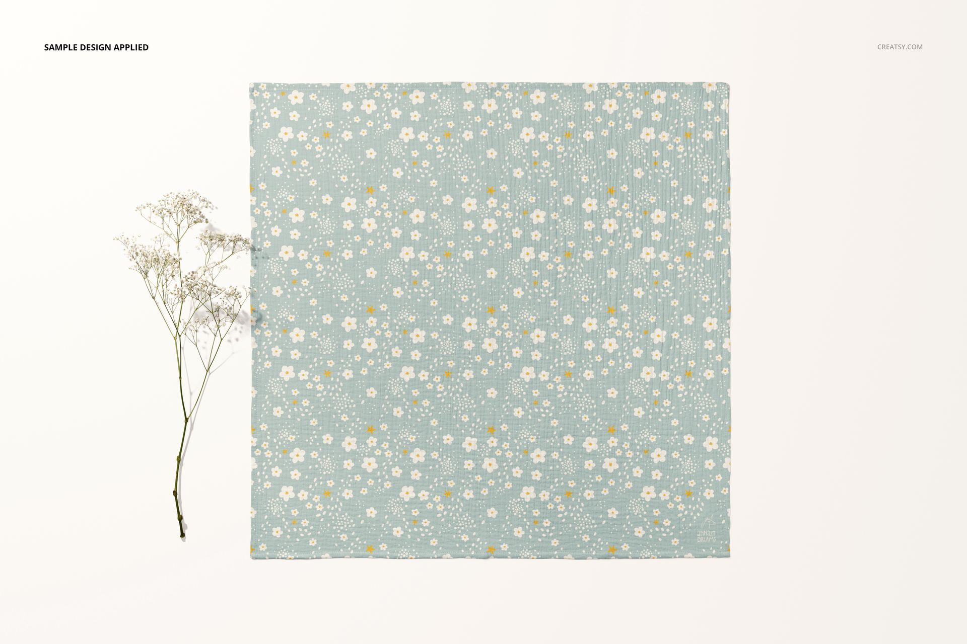 Crinkle muslin swaddle blanket mockup featuring a soft blue fabric with white and yellow flower print, flat lay style.