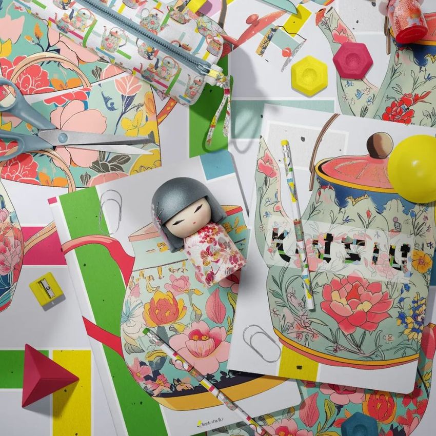 Stationery mockup scene featuring two classic A4 notebooks with colorful floral covers, surrounded by art supplies and paper props.