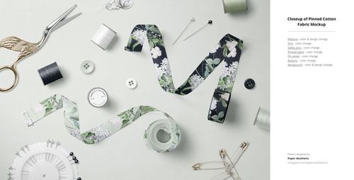 Fabric Factory v.9 PSD mockup showing floral-patterned fabric strips, buttons, thread spools, and sewing accessories from a top view.