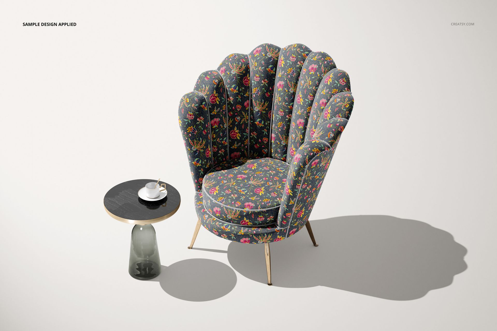 Mockup of a shell-shaped velvet armchair featuring a multicolored floral design, paired with a modern side table and cup.