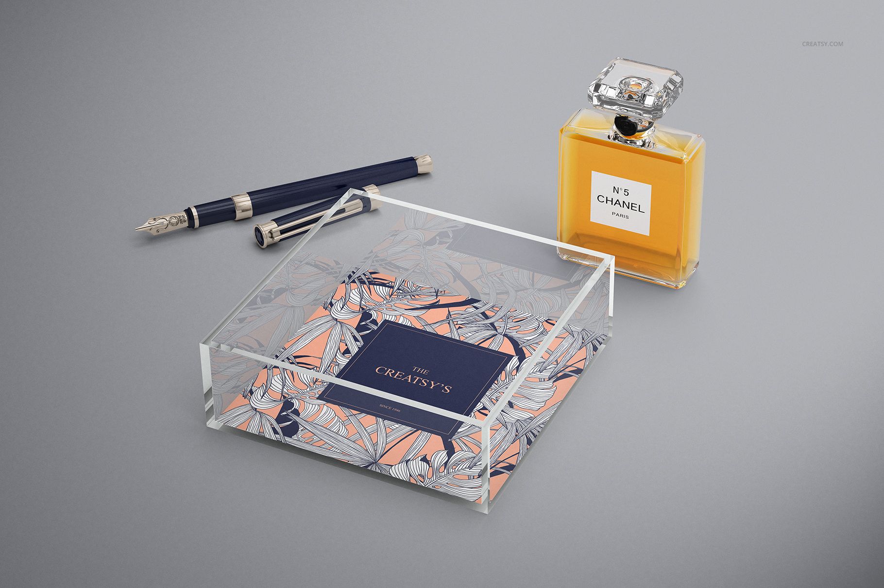 Lucite tray mockup featuring a clear acrylic design and patterned insert, displayed next to a perfume bottle and pens.