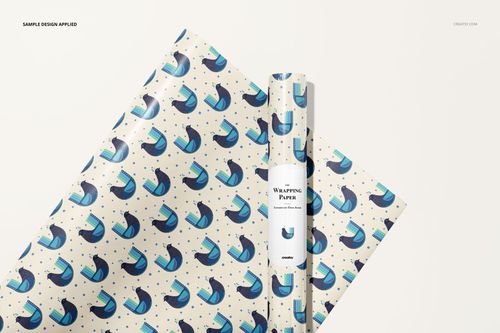 Gift wrapping paper mockup featuring a rolled sheet and flat sheet with blue and black abstract pattern on white.