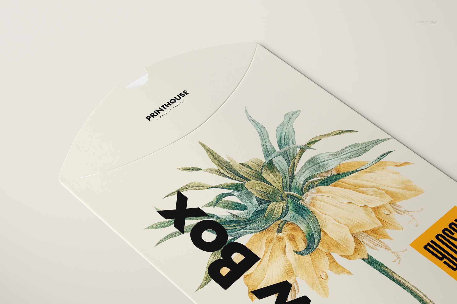 Pillow box mockup in a glossy finish, decorated with yellow and green flower artwork, viewed from above.