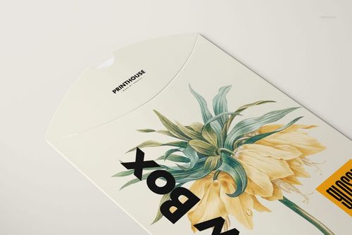 Pillow box mockup in a glossy finish, decorated with yellow and green flower artwork, viewed from above.