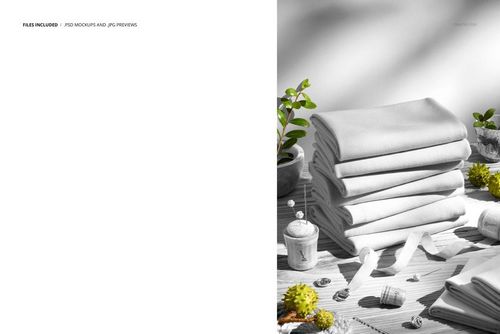 Jersey fabric pile arranged neatly on a wooden surface with greenery and sewing tools, shown in a PSD mockup scene.