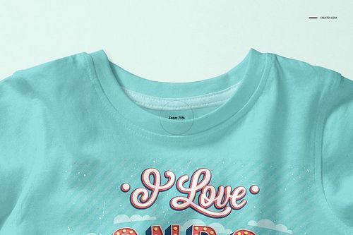 Front view of a baby T-shirt mockup in light blue with colorful printed text and graphic details on the chest area.
