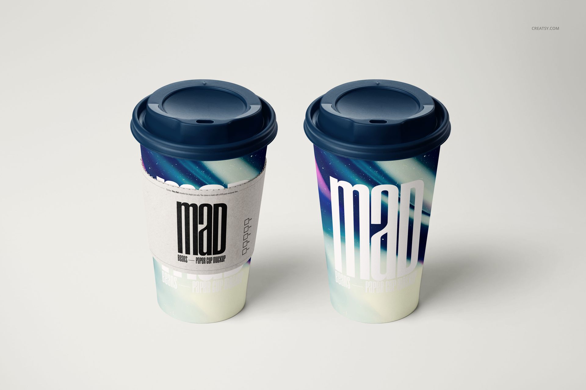 PSD mockup of drinkware showing two coffee cups with colorful patterns and navy lids, set against a plain backdrop.
