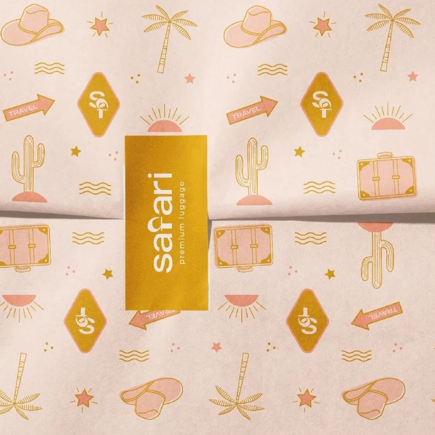 Wrapping paper mockup with a safari-themed pattern featuring cacti, hats, arrows, and a suitcase in gold on a pale background.