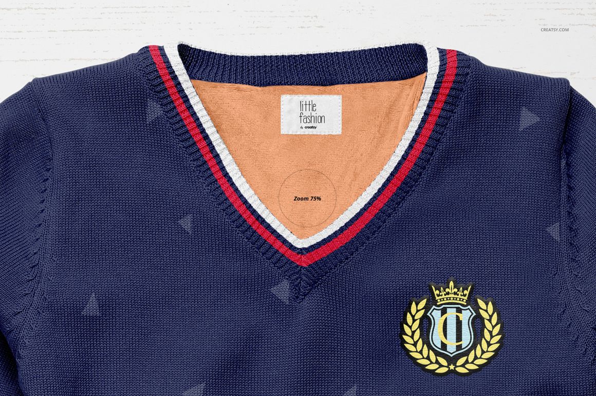 Front view of a boys sweater mockup in navy blue with a V-neck, red and white striped trim, and crest emblem on chest.