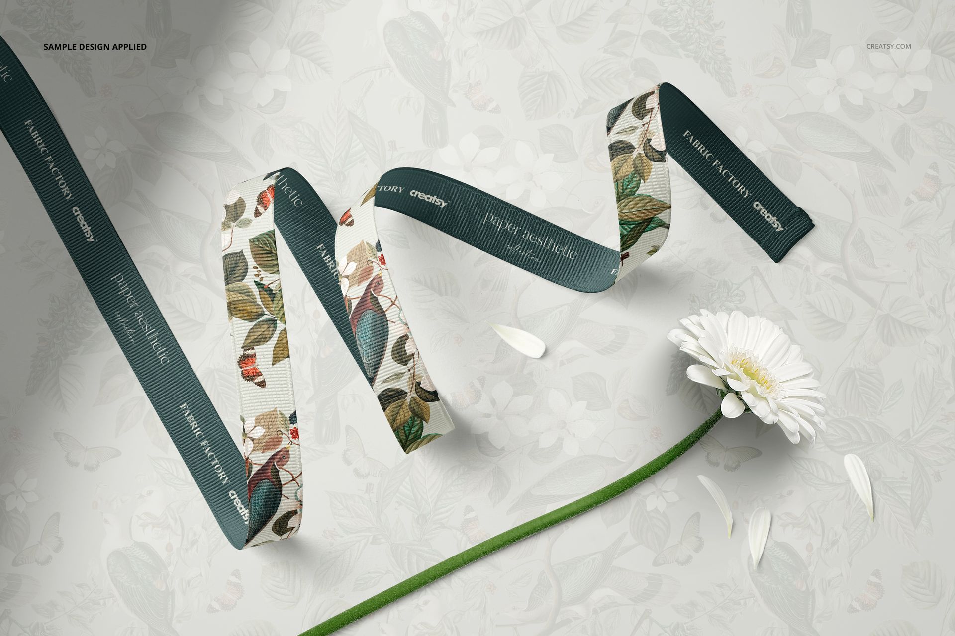 PSD mockup showing a flower and grosgrain ribbon with botanical prints and teal accents, viewed from above.