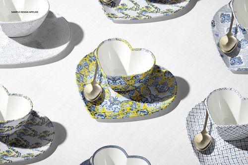 Multiple heart-shaped cup mockups with patterned saucers and metallic spoons, viewed from a top angle on a white background.
