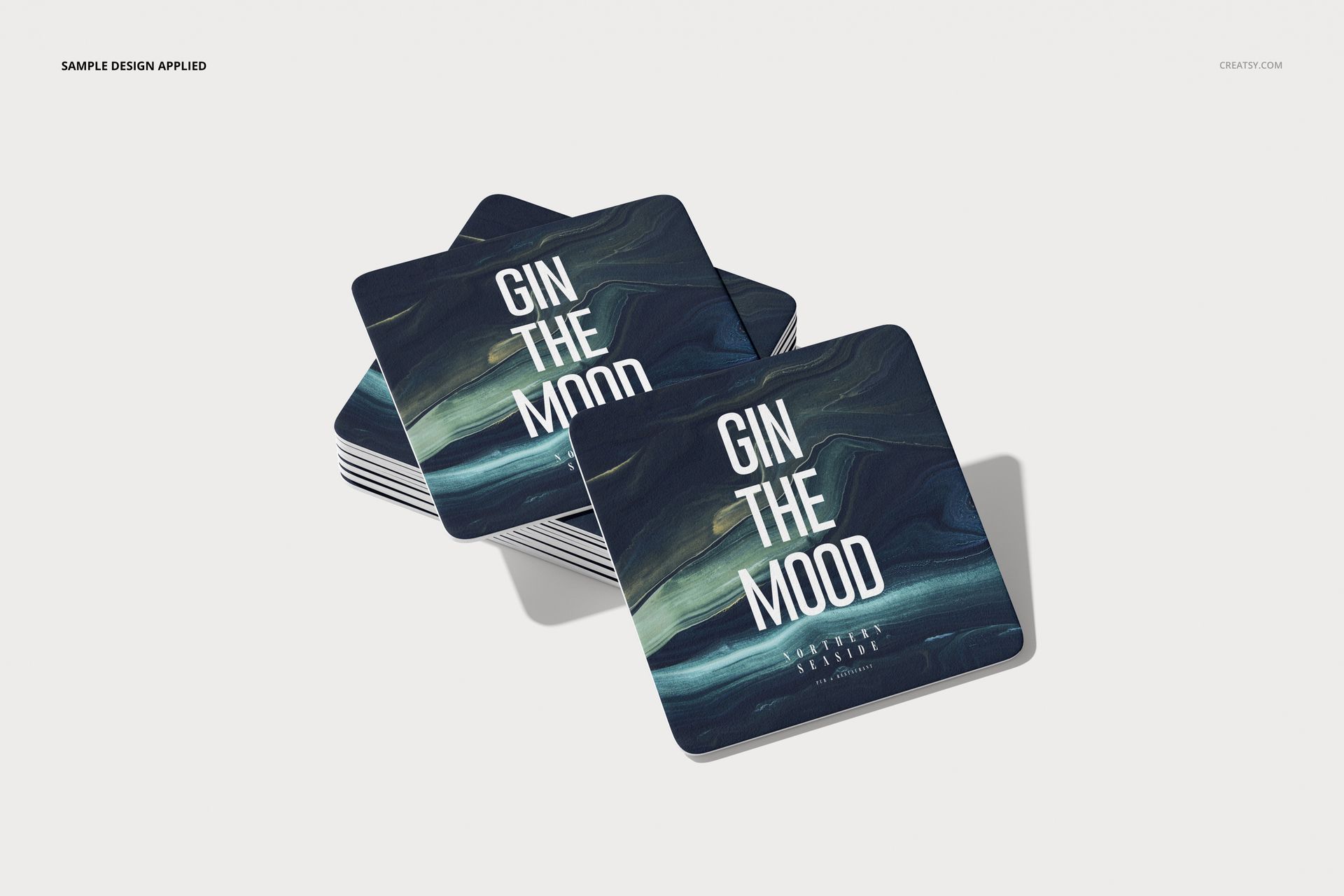 Square coasters mockup featuring layered coasters with a navy and green marbled pattern and bold white lettering.