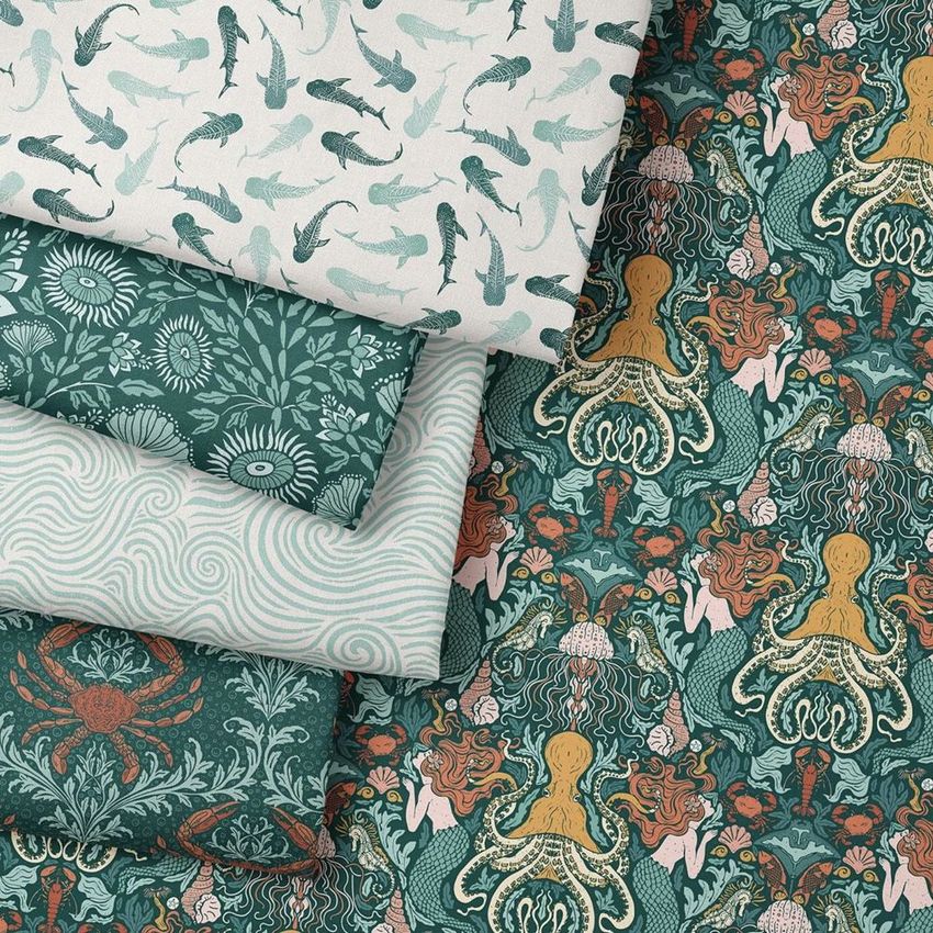 Folded fabrics mockup displaying four textile samples with marine-inspired patterns, including octopus, fish, and floral designs.