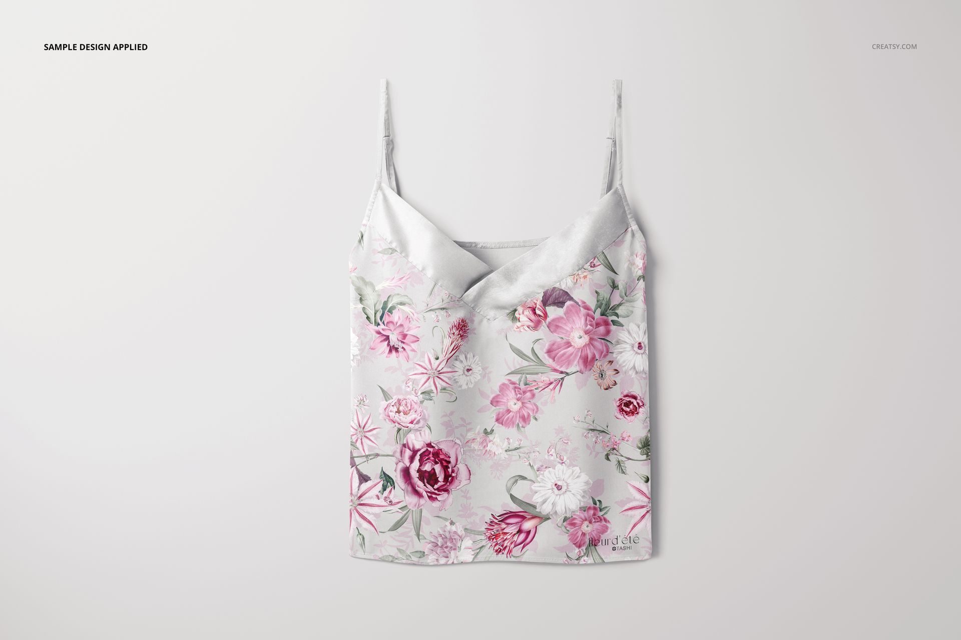 Front view of a short silk pajama top mockup with thin straps, featuring a pink and white floral pattern on a light background.