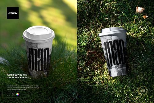Mockup of a paper cup with a lid featuring bold black lettering, placed on lush grass in natural daylight.