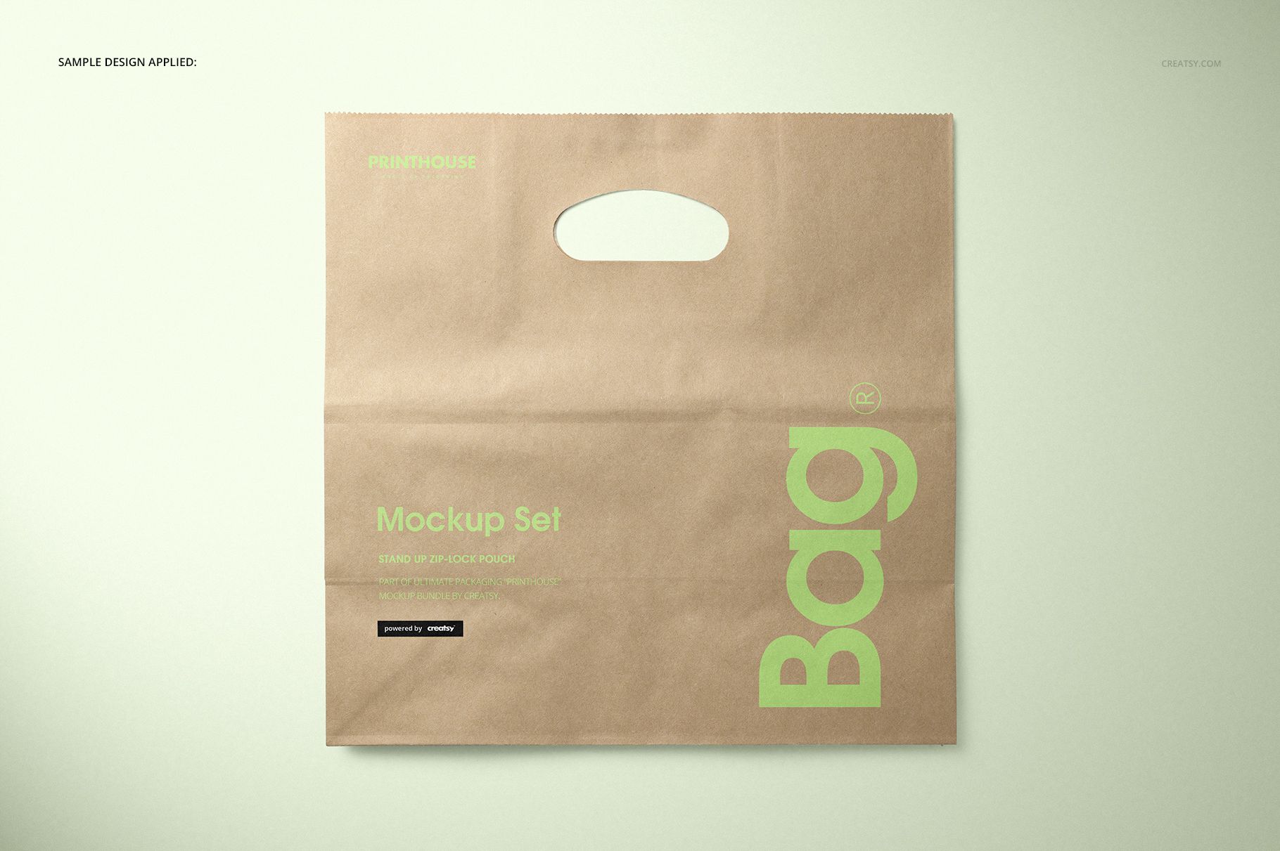 Front view of a die cut kraft paper bag mockup with a handle, featuring green text and minimal design on a light background.